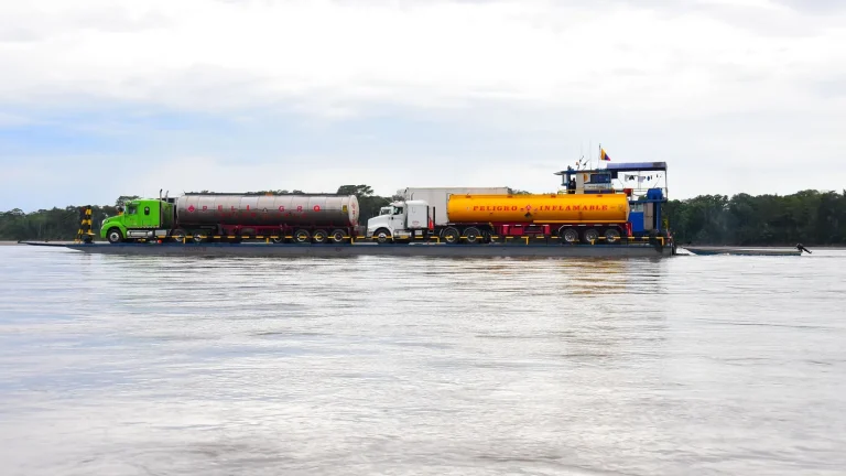 Caminhões-tanque transportados em balsa sobre rio