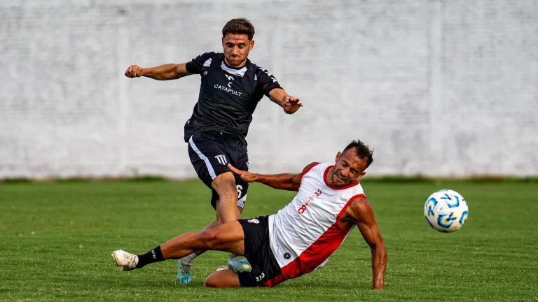 Dois jogadores de futebol disputam a bola em campo