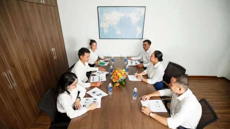 Grupo de pessoas reunido em mesa durante encontro de trabalho