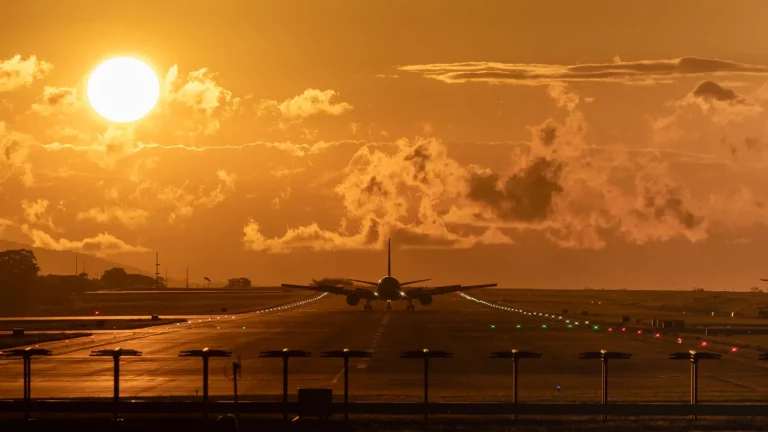 Avião comercial na pista do aeroporto ao entardecer