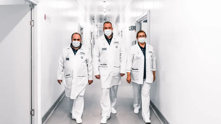 Equipe médica caminha por corredor de hospital