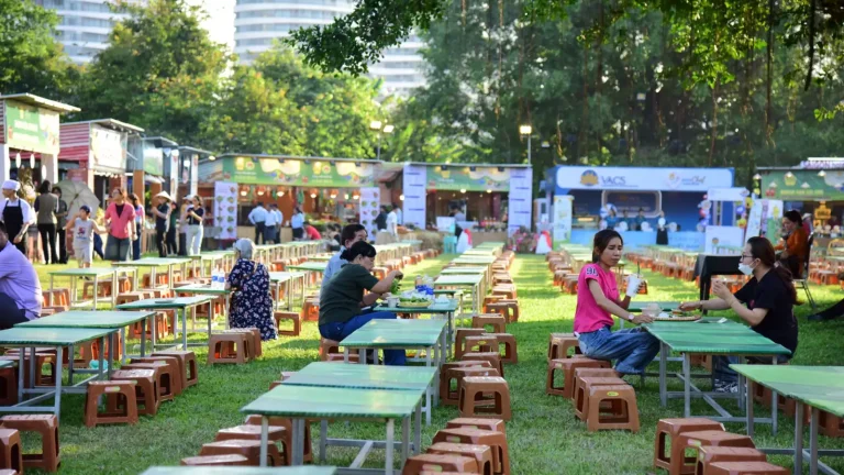 Público em festival gastronômico ao ar livre com mesas